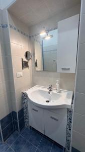a bathroom with a white sink and a mirror at A Casa di Cleo in Trieste +2 photos