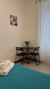 a table in a room with chairs and a table with a plant at A Casa di Cleo in Trieste
