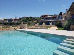 a swimming pool in front of a house at Viento Boutique in Skafidia