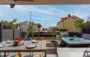 メドゥリンにあるLuxury apartment near the beachのパティオ(テーブル、椅子、ホットタブ付)