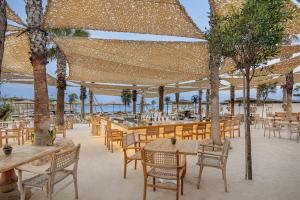 an outdoor restaurant with tables and chairs and trees at Cullinan Belek in Belek