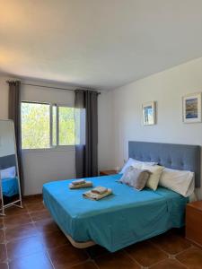 a bedroom with a blue bed with two towels on it at Apartamento Mar & Pins in Llucmajor