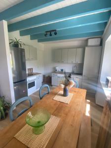 a kitchen with a wooden table and a blue ceiling at Maison calme in Bazouges-sous-Hédé