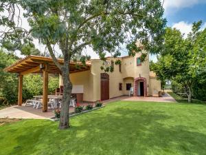 a house with a patio and a yard at Villa in Palafolls with Private Pool & BBQ in Palafolls