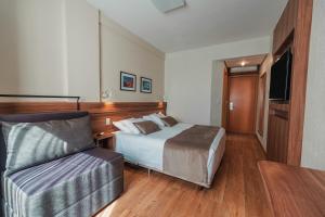 a hotel room with a bed and a couch at Hotel Laghetto Viale in Gramado