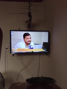 ein Fernseher, der an einer Wand hängt und auf dem ein Mann sitzt in der Unterkunft Evsam in Belém