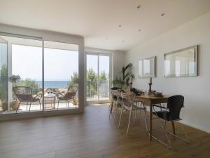 Un comedor con mesa y sillas y el océano. en Seafront Apartment in Calella with Beach Access, en Calella