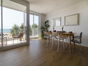 Un comedor con mesa y sillas y una gran ventana. en Seafront Apartment in Calella with Beach Access, en Calella