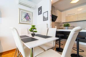 Una cocina y un comedor con una mesa y sillas blancas. en Flexible SelfCheckIns 79 - Zagreb - Garage - New, en Zagreb