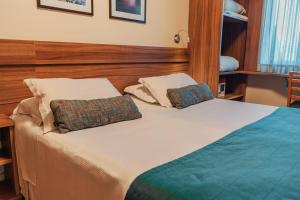 a bedroom with a bed with two pillows on it at Hotel Laghetto Viale in Gramado