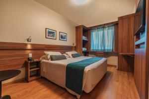 a hotel room with a bed and a television at Hotel Laghetto Viale in Gramado