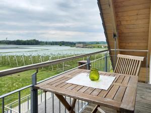 a wooden table on a balcony with a view of the water at Waldsuite in Friedrichshafen