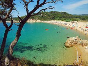 a beach with a large group of people in the water at Holiday Home in Palamós near the Beach in Palamós