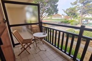 een balkon met twee stoelen en een tafel bij T2 cosy - vue sur le golf - proche plage in Pornic