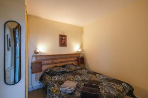 een kleine slaapkamer met een bed in de hoek bij T2 cosy - vue sur le golf - proche plage in Pornic