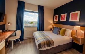 um quarto com uma cama, uma escrivaninha e uma janela em DCU Rooms em Dublin