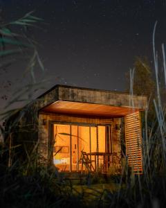 a small cabin with a window at night at Le Piloti in Saint-Quentin-en-Tourmont