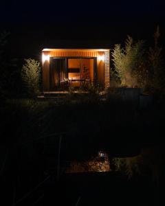 a house with lights on the side of it at night at Le Piloti in Saint-Quentin-en-Tourmont