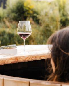 a glass of wine sitting on top of a table at Le Piloti in Saint-Quentin-en-Tourmont