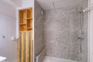 een douche in een badkamer met een douchegordijn bij T2 cosy - vue sur le golf - proche plage in Pornic