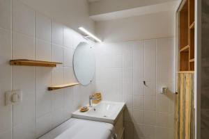 een witte badkamer met een wastafel en een spiegel bij T2 cosy - vue sur le golf - proche plage in Pornic