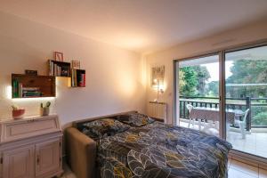 een slaapkamer met een bed en een groot raam bij T2 cosy - vue sur le golf - proche plage in Pornic +9 foto's