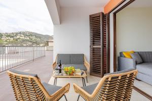 einen Balkon mit Stühlen, einem Tisch und einem Sofa in der Unterkunft Panoramic Views in Peaceful Tala in Tala
