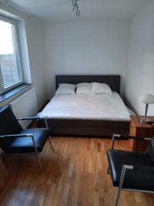 a bedroom with a bed and two chairs in it at apartment Amsterdamstr 1st fl in Ostend