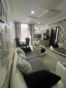 a living room with a couch and chairs and a table at Vato Apartment in Kobuleti
