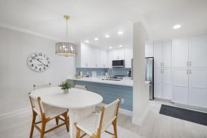 cocina con mesa, sillas y reloj en Coquina Beach 3A, en Sanibel