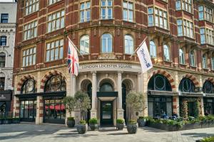 a large brick building with flags in front of it at Radisson Blu Hotel, London Leicester Square in London