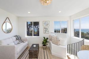 a living room with a couch and a table at Oceanfront Coastal Home with Breathtaking Views Hiking Beaches & More in Moss Beach +44 photos