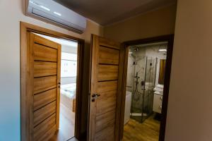 a hallway with two doors and a bedroom with a shower at VacationClub - Gierczak 15 Apartament 10 in Kołobrzeg