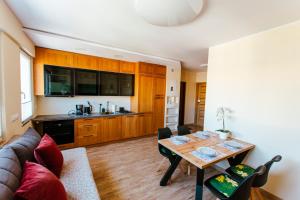 a living room with a table and a kitchen at VacationClub - Gierczak 15 Apartament 10 in Kołobrzeg