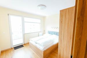 a bedroom with a bed and a large window at VacationClub - Gierczak 15 Apartament 10 in Kołobrzeg