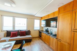 a bedroom with a bed and a kitchen with a sink at VacationClub - Gierczak 15 Apartament 10 in Kołobrzeg +6 photos
