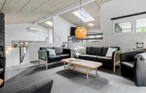 a living room with couches and a table at Awesome Home In Glesborg With Sauna in Fjellerup Strand