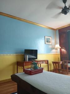 a room with a bed with a blue wall at KC Spa Hotel Kota Kinabalu in Kota Kinabalu