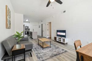 a living room with a couch and a tv at CozySuites in Glendale - Westgate with pool 11 in Glendale