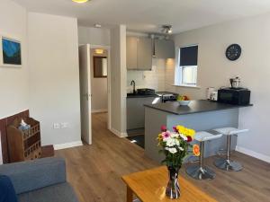 a kitchen and living room with a vase of flowers on a table at 112 Clifden Glen in Clifden +4 photos