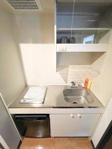 a small kitchen with a sink and a toilet at パルム天神西 in Susakiuramachi