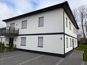 a white building with a balcony on the side at Gartenstraße 22 Haus E Wohnung DG in Stick