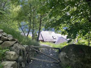 un portail devant un mur de pierre et une maison dans l'établissement Maison de charme 5 chambres, jardin central à Cauterets - FR-1-812-133, à Cauterets