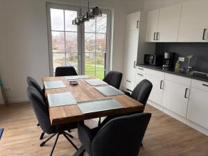 a kitchen with a wooden table and black chairs at Gartenstraße 22 Haus E Wohnung DG in Stick