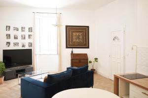 a living room with two blue couches and a television at Appartement Centre-Ville in Avignon +6 photos