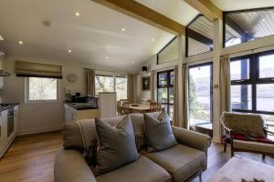 a living room with a couch and a kitchen at Sixpenny Bay in Morenish