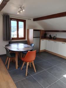 une cuisine et une salle à manger avec une table et des chaises dans l'établissement Lac et étoiles, à Savines 5 autres photos