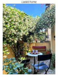 einen Tisch und Stühle unter einem Baum mit Blumen in der Unterkunft Leda's Home in Rom