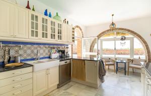 a kitchen with white cabinets and a dining room at Stunning Home In Conil De La Frontera in Conil de la Frontera