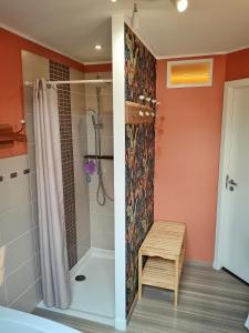 a bathroom with a shower with a bench next to it at Maison proche LA ROCHELLE & Ile de Ré in Sainte-Soulle +18 photos